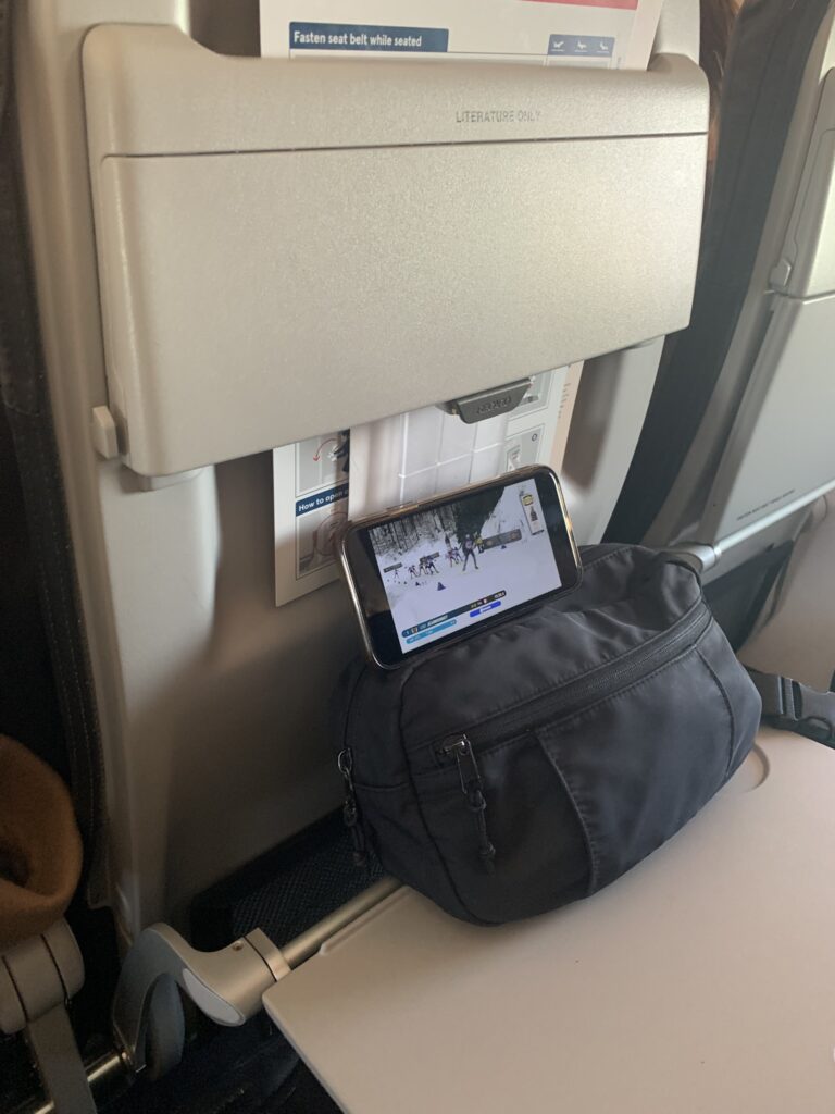 A picture taken on a plane showing a phone playing a biathlon race